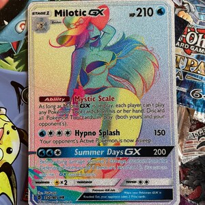 May include: A holographic Pokemon trading card featuring Milotic GX, a water-type Pokemon with a pink, blue, and yellow color scheme. The card has a HP of 210 and features the abilities Mystic Scale and Hypno Splash. The card also has a GX attack called Summer Days GX.