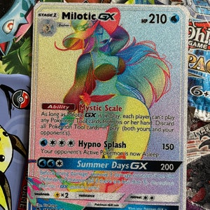 May include: A holographic Pokemon trading card featuring Milotic GX, a water-type Pokemon with a pink and blue color scheme. The card has a HP of 210 and features the abilities Mystic Scale and Hypno Splash. The card also has a GX attack called Summer Days GX.