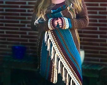 May include: A brown crocheted cardigan with a teal, brown, and white striped pattern. The cardigan has fringe along the bottom and sleeves. The cardigan is worn by a person with long brown hair.