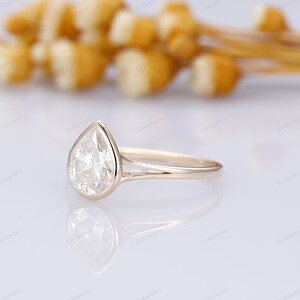 Pu&ograve; includere: Un anello di fidanzamento con diamante a forma di pera con una fascia a doppia spalla in oro giallo.