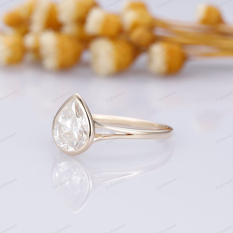 Pu&ograve; includere: Un anello di fidanzamento con diamante a forma di pera con una fascia a doppia spalla in oro giallo.