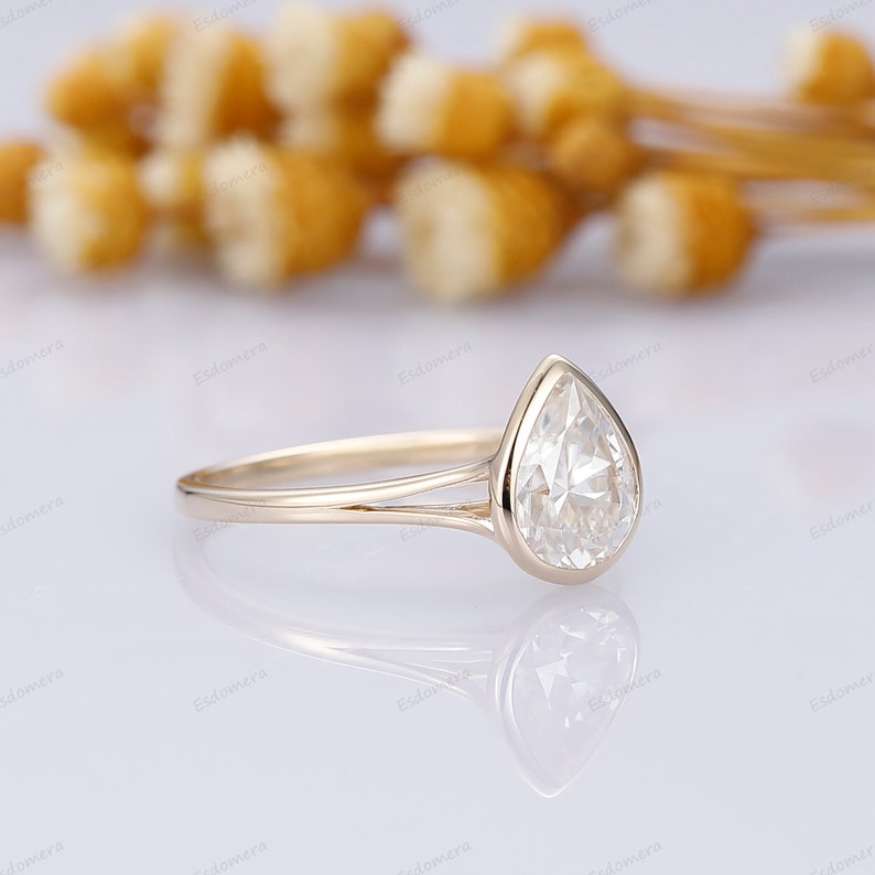 Pu&ograve; includere: Un anello di fidanzamento con diamante a forma di pera con una fascia a doppia spalla in oro giallo.