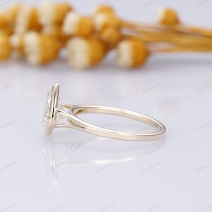 Pu&ograve; includere: Un anello di fidanzamento in oro con un grande diamante di forma ovale incastonato in una delicata montatura a griffe. L'anello ha una fascia sottile e un design semplice.