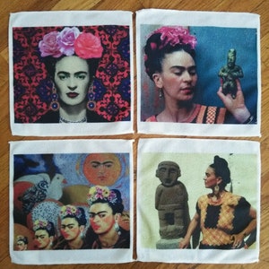 Puede incluir: Cuatro paños cuadrados blancos, cada uno con una imagen diferente de Frida Kahlo. Las imágenes incluyen retratos de Kahlo con tocados florales y uno sosteniendo una pequeña estatua. Los fondos varían en color y diseño.