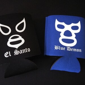 Pu&ograve; includere: Due refrigeratori per lattine in schiuma nera e blu con disegni di maschera da wrestling bianca. Il refrigeratore nero ha stampato "El Santo". Il refrigeratore blu ha stampato "Blue Demon".