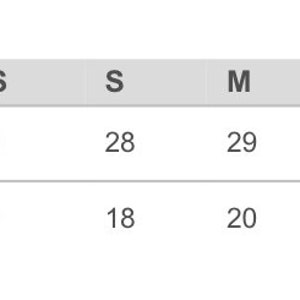 May include: A chart showing finished measurements for a garment in inches. The chart shows the size, body length, and chest width (laid flat) for sizes XS through 3XL.