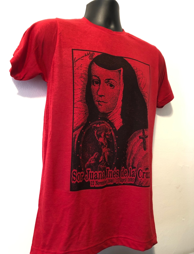 May include: Red t-shirt with a black and white image of Sor Juana In&eacute;s de la Cruz, a Mexican poet and nun. The image includes her name and dates of birth and death: 12 November 1648 - 17 April 1695.