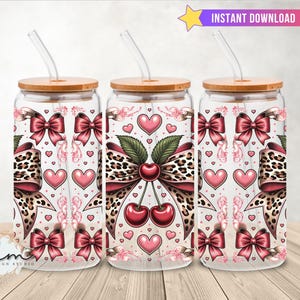 Op de afbeelding: Drie glazen bekers met bamboe deksels en doorzichtige rietjes. De bekers hebben een ontwerp met roze strikken, harten en kersen. Het ontwerp bevat een luipaardprint en de tekst "INSTANT DOWNLOAD".