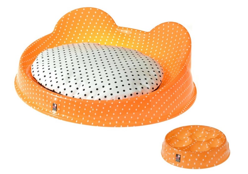 Puede incluir: Cama para mascotas naranja y blanca con un coj&iacute;n redondo extra&iacute;ble. La cama tiene un patr&oacute;n de lunares. Tambi&eacute;n hay un cuenco a juego naranja y blanco con cuatro compartimentos.