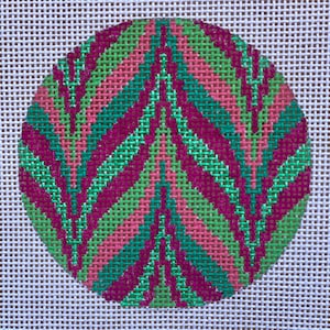 May include: A round ornament with a geometric pattern in shades of green, pink, and purple.