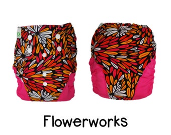 May include: A reusable cloth diaper with a pink and black floral print. The diaper has a pink trim and white snaps. The diaper is called "Flowerworks".