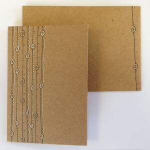 May include: Two brown cardstock cards with a decorative border of white lines and swirls on the left card. The right card has a decorative border of white lines and swirls on the right side.