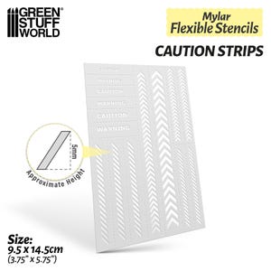 May include: A white Mylar stencil sheet with the text "CAUTION STRIPS". The sheet features various arrow and stripe designs, along with the words "CAUTION" and "WARNING". The stencil measures 3.75" x 5.75" (9.5 x 14.5cm).