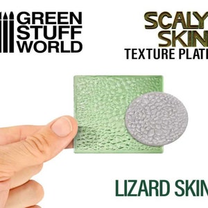 Puede incluir: Placa de textura de piel escamosa Green Stuff World, una placa de plástico verde claro con una textura de piel de lagarto en relieve. La placa está siendo sostenida por una mano. El texto "Scaly Skin Texture Plate" está impreso en la parte superior de la placa. El texto "Lizard Skin" está impreso debajo de la placa.