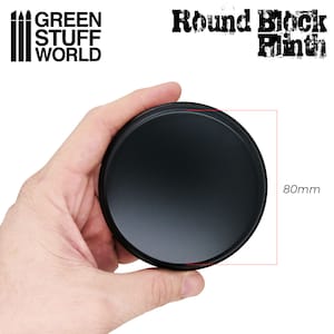 May include: A black, round product base, 80mm in diameter, held in a hand. The product is from Green Stuff World and is labeled "Round Block Plinth".