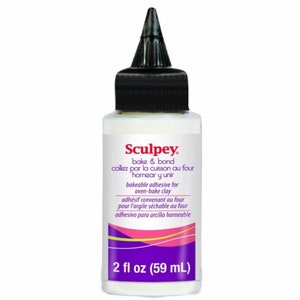 Puede incluir: Una botella blanca de adhesivo Sculpey bake and bond para arcilla horneable. La botella está etiquetada con instrucciones en inglés, francés y español. La botella contiene 59 ml (2 fl oz) de adhesivo.