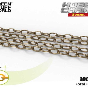 Peut inclure: Une chaîne de 100 cm de long, composée de maillons ovales en laiton, d'un diamètre de 3 mm. La chaîne est présentée sur un fond blanc. Le texte "HOBBY CHAINS 3 mm." est visible dans le coin supérieur droit de l'image.