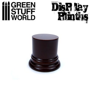May include: A dark brown wooden display plinth with a rounded top and a decorative base. The plinth is perfect for displaying small items, such as figurines, jewelry, or other collectibles.