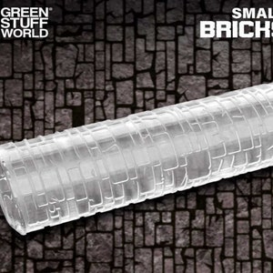 Könnte beinhalten: Eine transparente Plastikrolle mit einem kleinen Ziegelmuster, das auf die Oberfläche geprägt ist. Die Rolle ist zum Erstellen von Texturen auf Ton, Fondant oder anderen Bastelmaterialien gedacht. Der Text "SMALL BRICKS" ist in der oberen rechten Ecke des Bildes sichtbar.