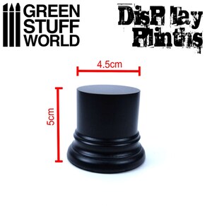 May include: Black display plinth with a diameter of 4.5 inches and a height of 5 inches.  The plinth has a decorative rim around the top and bottom.