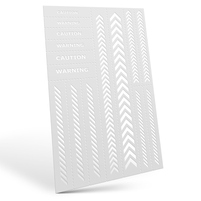 May include: A white stencil sheet with various arrow and line designs. The sheet includes the words "CAUTION" and "WARNING" in a repeating pattern. The designs are cut out, creating negative space.