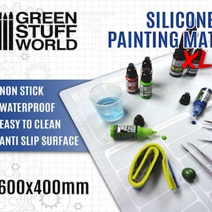 Può includere: Un grande tappetino da pittura in silicone bianco con un motivo a griglia e il testo "SILICONE PAINTING MAT XL" stampato su di esso. Il tappetino misura 600 mm x 400 mm e ha una superficie antiaderente, impermeabile, facile da pulire e antiscivolo. È progettato per hobbisti e artisti da utilizzare con vernici, pennelli e altri materiali per la pittura.