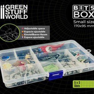 Può includere: Una scatola di contenimento in plastica trasparente con 15 scomparti per organizzare piccoli oggetti. La scatola è etichettata "BITS BOX" e misura 170x95 mm. La scatola è piena di vari piccoli oggetti, tra cui miniature e pezzi di gioco.