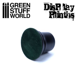 May include: Black display plinth with a green velvet top.  The plinth is a cylinder shape and is about 2 inches tall.  The text "Display Plinths" is visible in the background.