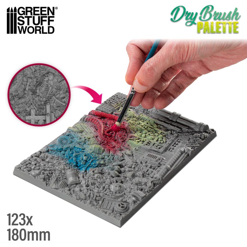 May include: A gray rectangular palette with a detailed, textured surface, featuring a miniature cityscape design. The palette is being painted with a brush, showcasing red, blue, and green dry brush techniques. The text "Dry Brush PALETTE" is visible.