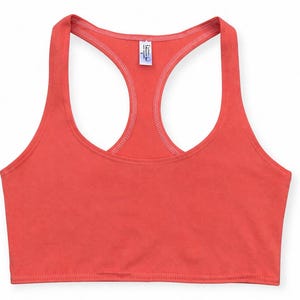 Può includere: Un top corto color corallo con schiena a vogatore. Il top presenta uno scollo tondo e un design a vogatore. Il tessuto sembra essere un materiale morbido e leggero. Il top è di colore pieno senza motivi o grafiche visibili.