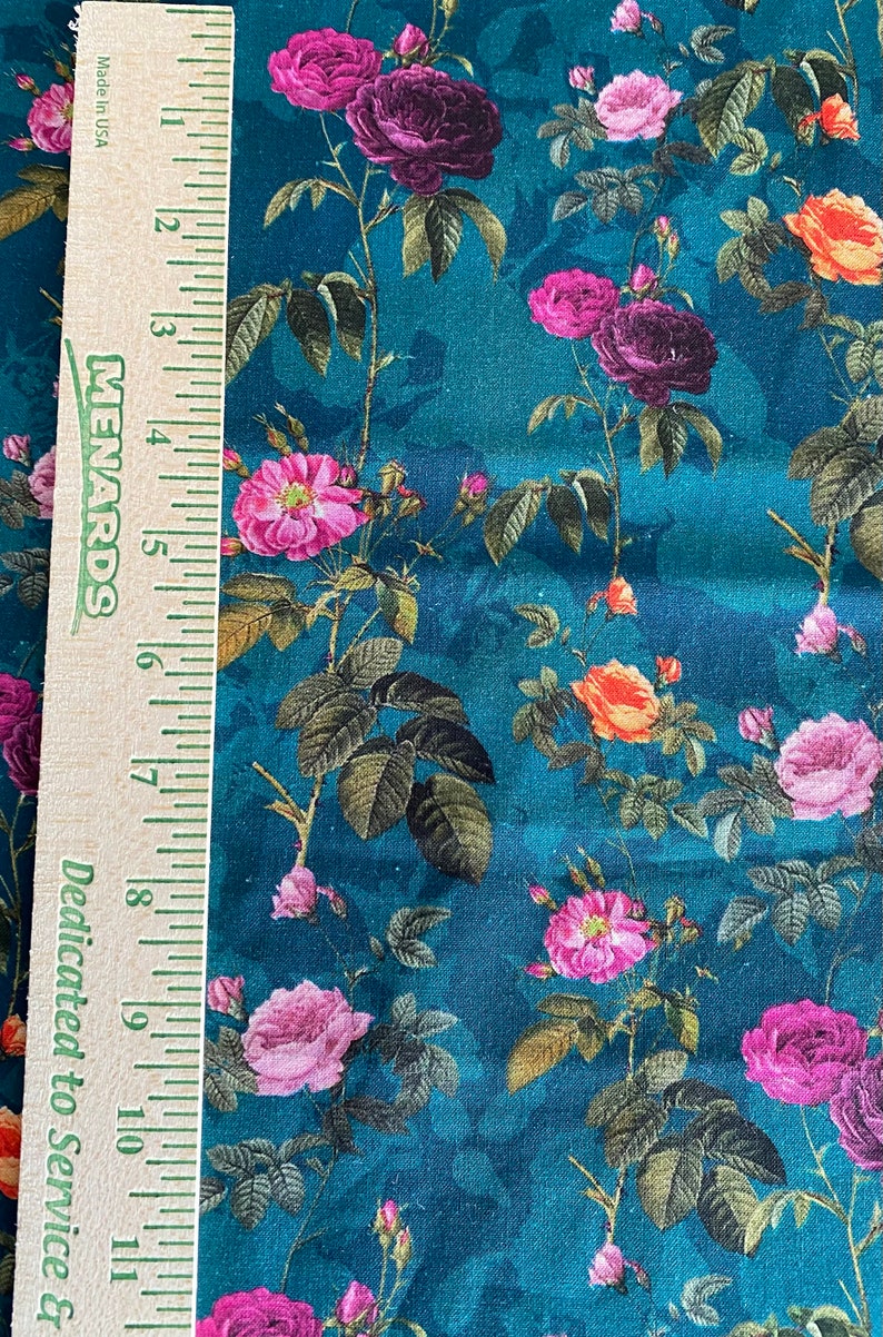 May include: Teal fabric with a floral pattern featuring pink, purple, and orange roses. The fabric is textured and has a vintage feel.