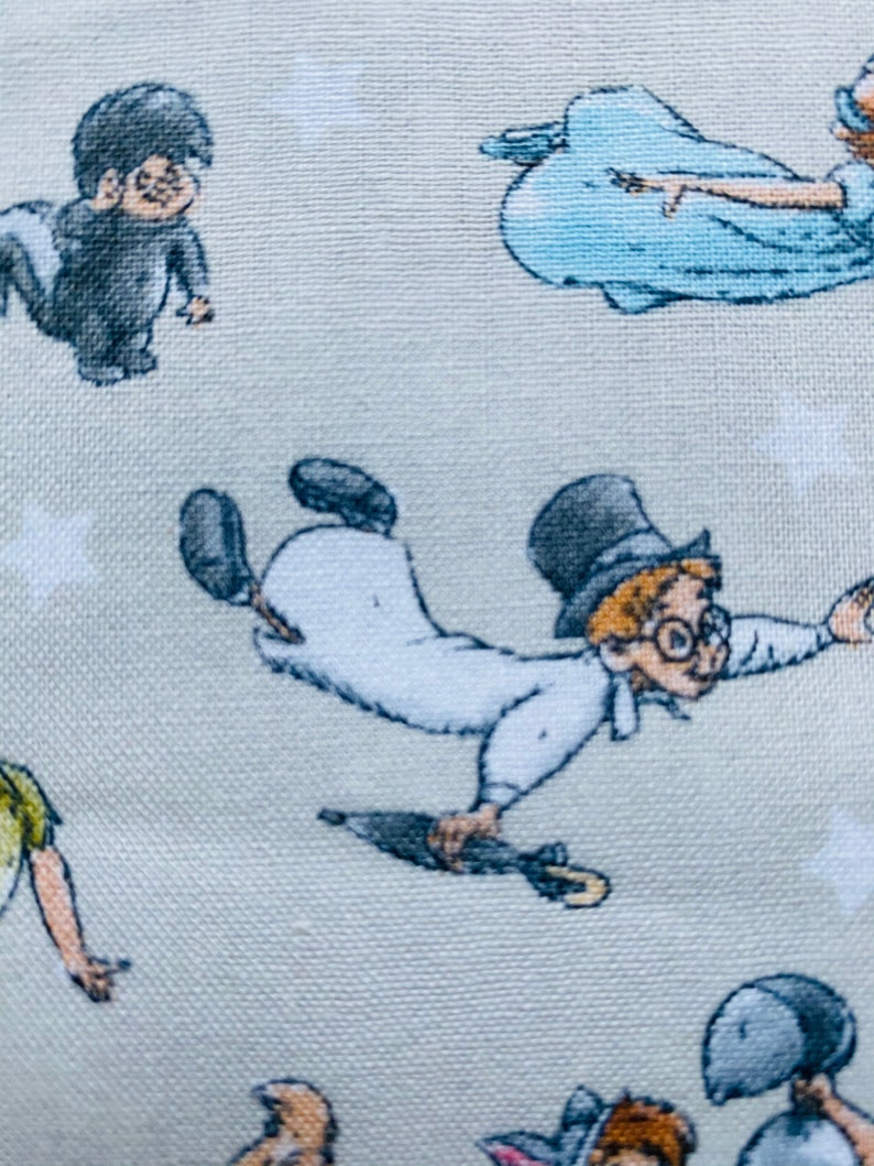 K&ouml;nnte beinhalten: Ein hellgrauer Stoff mit einem sich wiederholenden Muster von Figuren aus dem Film Peter Pan. Die Figuren sind Peter Pan, Captain Hook, Tinkerbell und Wendy. Der Stoff ist perfekt f&uuml;r Bastelprojekte wie Quilts, Kissen und Tragetaschen.