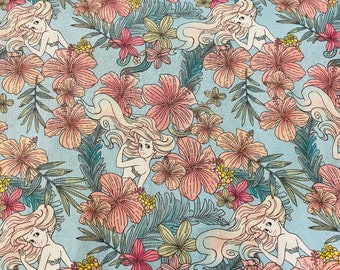 May include: A blue fabric with a repeating pattern of pink hibiscus flowers and mermaids with long flowing hair.