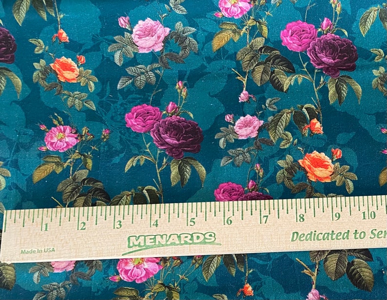 May include: Teal fabric with a floral pattern featuring pink, purple, and orange roses. The fabric is measured with a ruler that reads "MENARDS" and "Dedicated to Service".