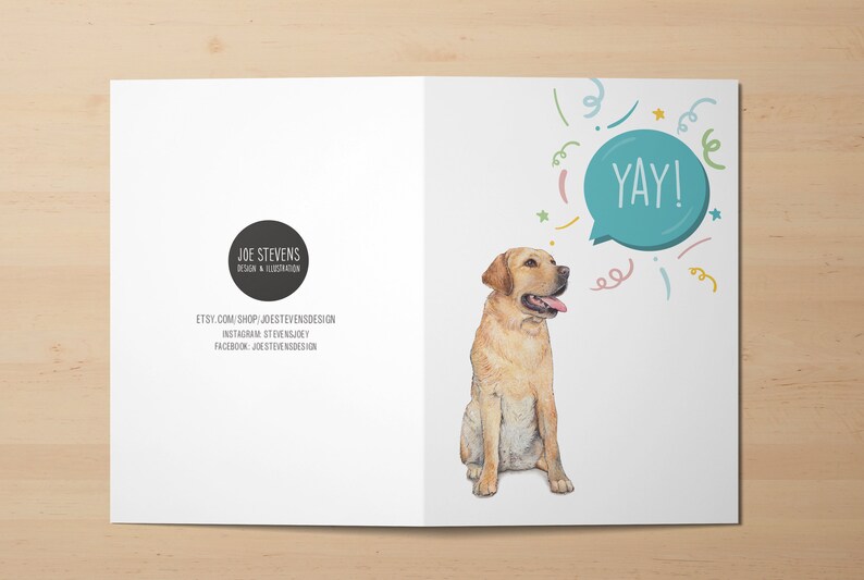 May include: Greeting card featuring a watercolor illustration of a yellow Labrador Retriever with its tongue out. A speech bubble says "YAY!" with colorful confetti. The card also includes the designer's logo and social media information.