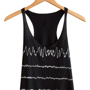 May include: A black tank top with a white graphic print of a repeating EKG line pattern.