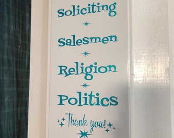 May include: A rectangular white sign with teal text that reads "No! soliciting, salesmen, religion, politics, thank you!" The sign is mounted on a white door with a black doorbell.