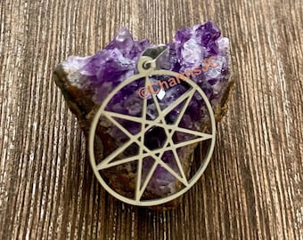 May include: A silver pendant with a eight-pointed star design, resting on a purple amethyst crystal.