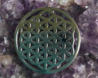 May include: A silver metal flower of life pendant resting on a bed of amethyst crystals.