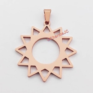 Op de afbeelding: Roze gouden hangerbedel in de vorm van een zon met een ronde uitsparing in het midden. De zon heeft een geometrisch ontwerp met punten die naar buiten stralen.