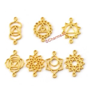 Könnte beinhalten: Sieben goldfarbene Metall-Anhänger mit verschiedenen Chakra-Symbolen. Jeder Anhänger hat zwei Ösen zum Anbringen an Schmuck.