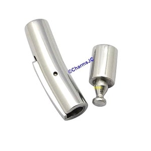 May include: Silver-toned metal bracelet clasp with a curved design and a separate push-button closure. The clasp is designed to be used with a bracelet or charm bracelet.