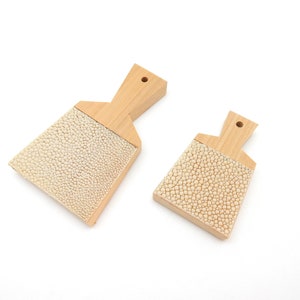 Peut inclure: Deux brosses en bois avec des poils texturés blancs. Les brosses ont des manches en bois et sont de tailles différentes.