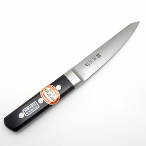 May include: A small, black-handled paring knife with a silver blade. The blade has Japanese text that reads "中研ぎ" which translates to "medium sharpening".