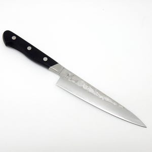 May include: A silver chef's knife with a black handle and a textured blade. The knife has a slightly curved blade and a pointed tip.