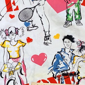 以下が含まれることがあります： 白い生地に、スポーツをしている人やハートを持っている人が描かれたカラフルな漫画のデザイン。生地は白地にピンク、青、黄、赤、黒のアクセントが施されています。