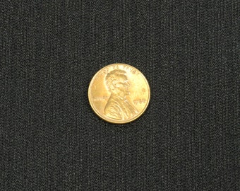 May include: A copper-colored US penny coin with the inscription "In God We Trust" and the year "1958" on the obverse side. The coin features a profile of Abraham Lincoln.