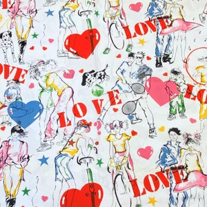以下が含まれることがあります： カラフルなイラストが繰り返し描かれた白い布。イラストには、人、ハート、星、赤い文字で「LOVE」が描かれています。人々は、自転車に乗ったり、テニスをしたり、手をつないだり、さまざまな活動をしています。