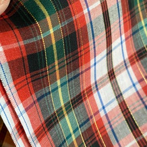 May include: Red, green, white, and black plaid fabric with gold thread woven into the design.