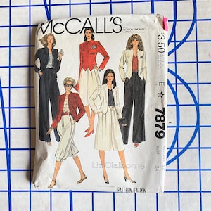 May include: A vintage McCall's sewing pattern envelope featuring illustrations of women's suits and separates. The envelope is white with text and a price tag. The pattern includes designs by Liz Claiborne.